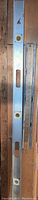 Full view of the metal levels and wooden ruler laid flat on wooden surface