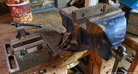 Overall view of both vises mounted on the workbench, visible wear, and surrounding workspace.