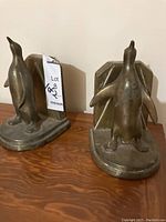 Front view of the two metal penguin bookends showing their shape and design.