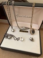 Jewelry set in Gloria Vanderbilt box showing two stud earrings and three pendant necklaces with cubic zirconia stones.