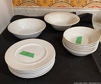 Full view of all dishes including 2 large serving bowls, 7 dessert plates, and 7 dessert bowls arranged on a black cloth.