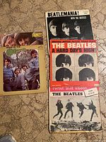 Five vintage vinyl LP records visible including 'More of The Monkees', 'Beatlemania! With the Beatles', 'A Hard Day's Night' soundtrack, and 'Twist and Shout'. Covers show age and wear.