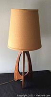Full side view of the Mid-Century Modern wood lamp with beige textured shade showing overall design and height.