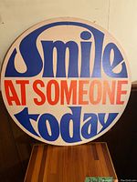 Front side of the sign showing colorful bold text in blue and red on light background.