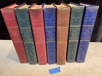 Seven volumes of The Great Events of the Great War arranged side by side showing varied cloth colors, red, green, blue, and brown with gold embossed titles and decorations on spine.