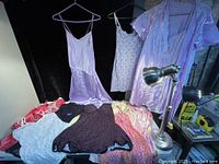View of ten ladies delicate clothing items including nightgowns, slip dresses, camisoles in pastel and patterned fabrics
