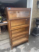 Front view of assembled four-section oak bookcase with all sliding glass doors closed