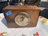 Front and side views of the rectangular Art Deco mantel clock showing clock face, wood case, and black corner accents.