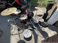 Full drum kit outdoors showing bass drum, mounted toms, snare, floor tom, cymbals, and drum throne