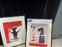 Pair of framed prints side by side showing Black Dog Licorice and Schnauzer Chocolate Bar advertisements