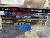 Side view of the five-season set of Sons of Anarchy on DVD and Blu-ray showing spine titles and disc counts