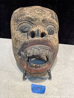 Front view of the vintage Tibetan carved wood mask showing detailed facial features and open mouth with teeth.