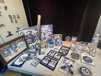 Wide shot showing the variety of Toronto Maple Leafs collectibles including framed mini jerseys, bobbleheads, pucks, trading cards, signed photos, and a wooden mini hockey bat.