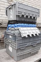 Stack of gray plastic bins with some having full or partial doors, showing size and color details