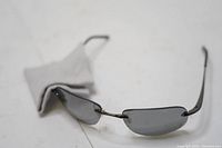 Bolle rimless sunglasses with dark lenses and cloth, showing lightweight frame and typical sunglasses wear including cracks.