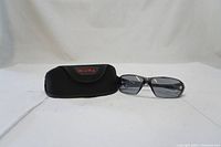 Bolle Prism safety glasses displayed next to black protective case on white background.