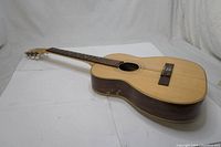 Full view of the guitar showing spruce top and rosewood sides with nylon strings.