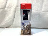 Front view of the sealed Joby GorillaPod Action Tripod box showing branding, product name, and image of use with a cyclist on rocky terrain.