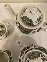 Overhead shot of tea pot, coffee pot, and sugar bowl with lids, showing detailed Windsor pattern and floral design.