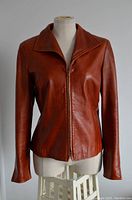 Front view of brown leather jacket showing zipper closure and collar