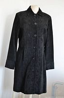 Full front view of black suede leather jacket on mannequin showing decorative braid embroidery patterns and button closure.