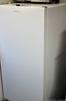 Exterior front and right side of white Frigidaire upright freezer with closed door