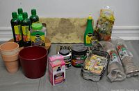 Full view of all gardening items arranged including pots, bottles, peat pellets, kneeling pad, and soil enhancer bag