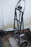 Full view of the metal hand truck dolly, showing the frame, handles, and base plate against a white background.