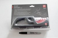 Photo of the front of the sealed packaging showing the Henckels Zwilling 4-stage sharpener with ergonomic black handle and red/stainless steel sharpening slots.