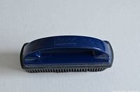 Blue Norwex rubber brush, front view showing rubber bristles and top handle