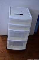 White rolling plastic storage drawers with a Sharpie on top showing size and usage of surface.