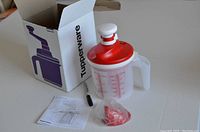 Tupperware Whip'N Mix Chef container with handle and red and white lid, alongside instruction manual and box