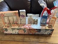 Photo showing assorted boxed and wrapped bath gifts arranged on a wooden surface including Bulgarian Yoghurt Skin set, Crabtree & Evelyn Freesia bath gel and more.