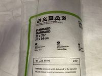 Close-up showing label of IKEA GOSA SLAN pillow with size, fabric and care instructions.