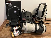 Overview of camera body, telephoto zoom lens, battery charger, batteries, lens case, camera box and backpack