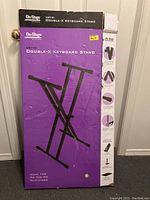 Photo of original packaging box for On-Stage Stands KS7191 Double-X Keyboard Stand with product images and details.