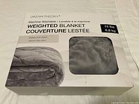 Front of original product box showing brand, product name, weight (15 lbs/6.8 kg), and grey folded weighted blanket image.