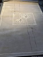 Full view of the beige area rug with floral design and border