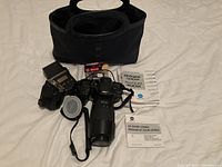 Overview of all included items: Minolta Maxxum 400si camera with zoom lens, two external flashes, battery, lens filter, instruction manuals, and carrying case on white background.