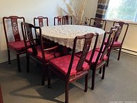 Dining table with hand-crocheted tablecloth and surrounding 12 chairs