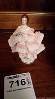 Front view of the Dresden porcelain ballerina figurine showing facial features, pink dress with lace ruffles, and round base.