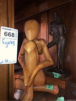 Photo showing the two figurines from front angle on shelf with size tags 12" and 14".