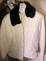 Front view of white quilted jacket with black velvet collar, showing zippered front and pockets.
