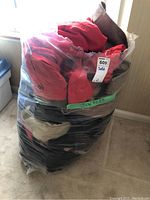 Photo of packed jackets showing red, brown, beige, and black jackets inside a clear plastic bag labeled 'Jackets'.
