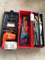 Black & Decker two-speed orange jigsaw in black plastic carrying case with various blades and accessories, red toolbox with saw and cutters
