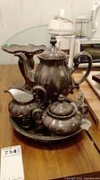 Full coffee set on table including coffee pot, creamer, sugar bowl, and serving tray.