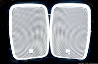 Pair of white Bowers & Wilkins outdoor stereo speakers with perforated metal grille and logo.