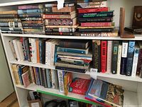 Three-tier shelf with assorted fiction and non-fiction spines visible