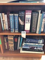 Photo showing two shelves of books primarily focused on music, literature, Canadian literature, and art. Books are mostly hardcover with some paperbacks visible, with titles visible including The Oxford Companion to Music and The Cambridge Guide to Literature in English.