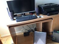 Full desk setup with Dell monitor, keyboard, mouse, speakers, and HP Envy 7640 printer on wooden desk.